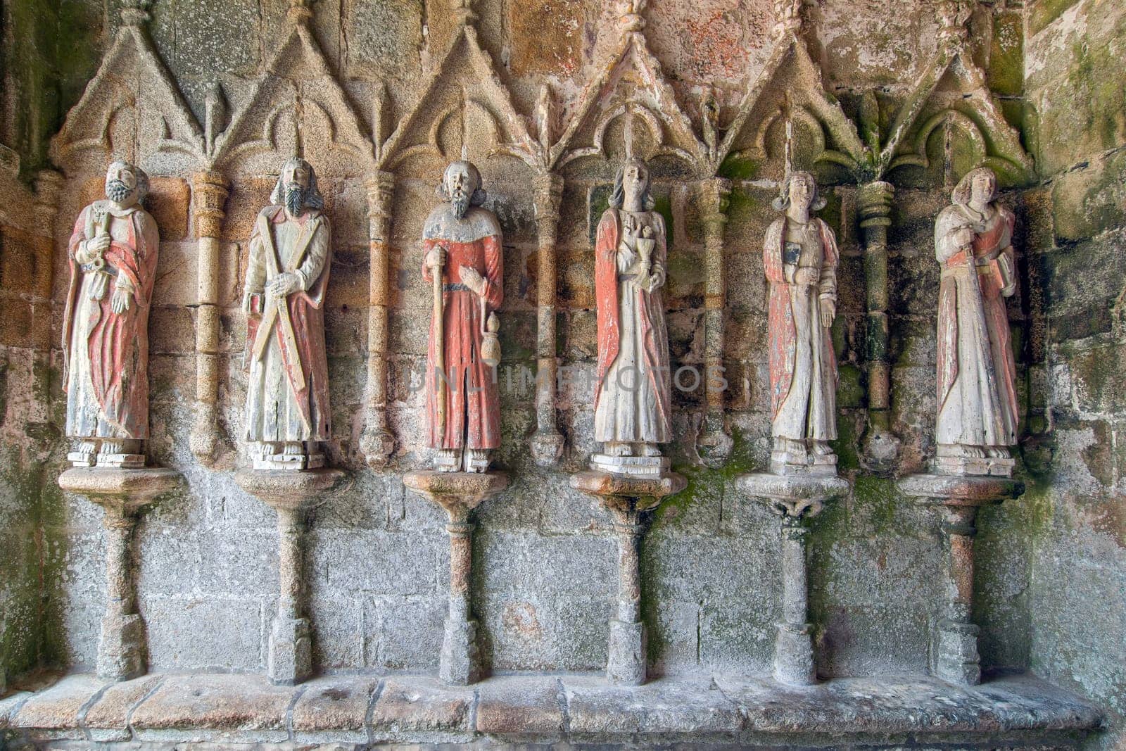 Plouha, France, August 15, 2019: Chapel of Kermaria an Iskuit - medieval wooden statues of saints - apostles - at the entrance to the chapel of Kermaria an Iskuit from 13th century