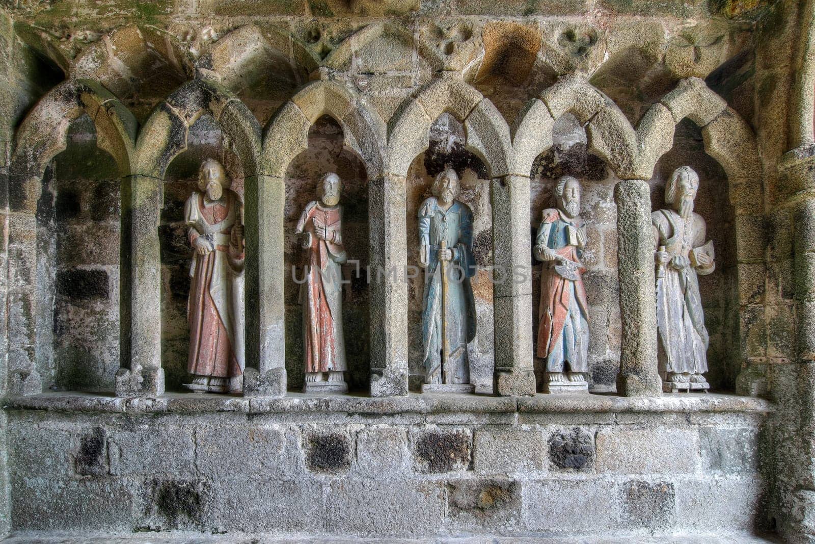 Plouha, France, August 15, 2019: Chapel of Kermaria an Iskuit - medieval wooden statues of saints - apostles - at the entrance to the chapel of Kermaria an Iskuit from 13th century