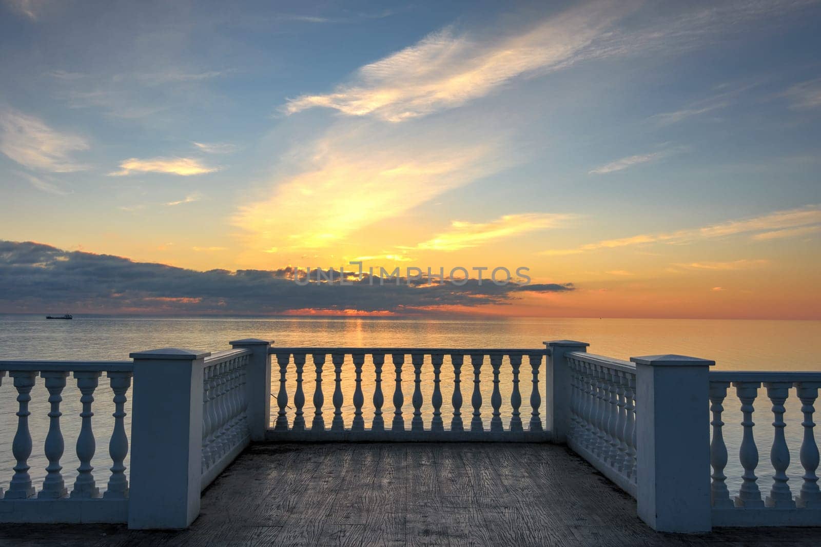 Beautiful building with columns on a landscaped promenade at sunset