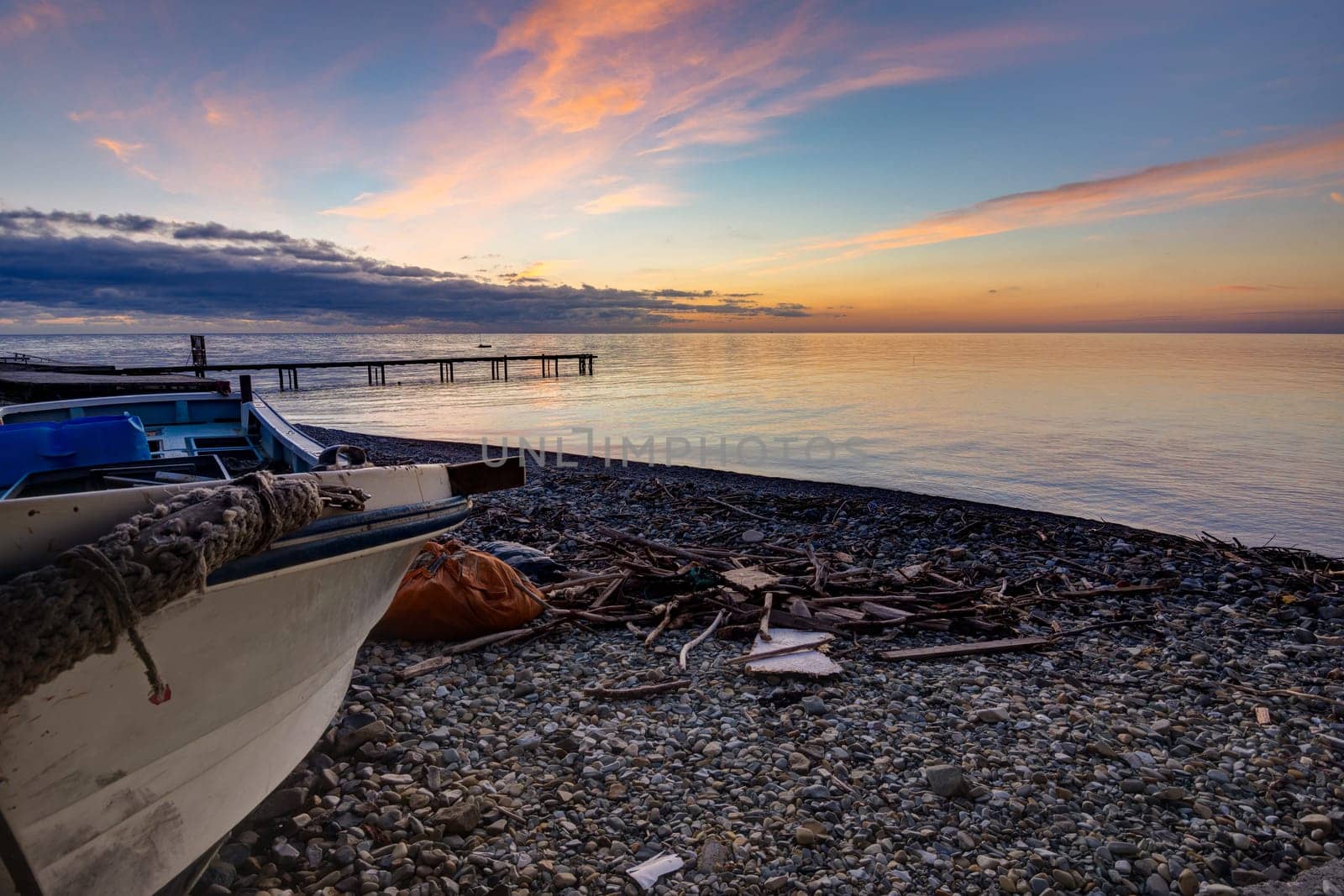 Beautiful landscape with a boat by the sea at sunset