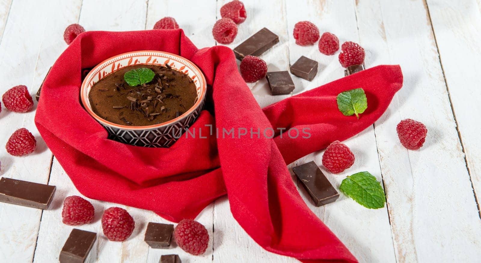 Homemade chocolate mousse with  raspberry on white wooden background