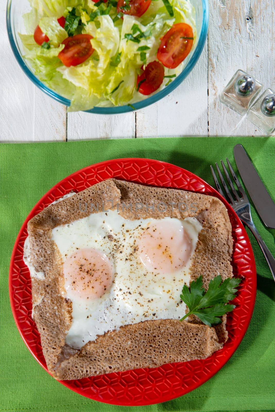 homemade Breton crepe with egg in a red plate