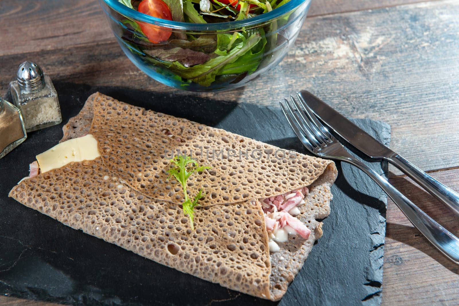 Breton crepe with cheese and bacon on the wooden background