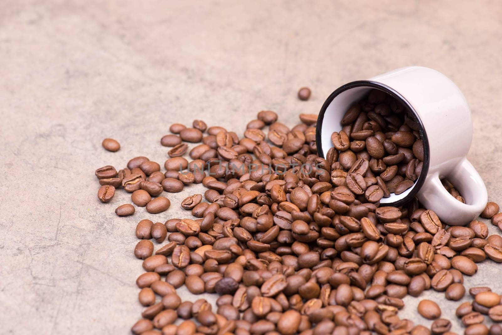Roasted coffee beans on a brown textured background, hot drink ingredients