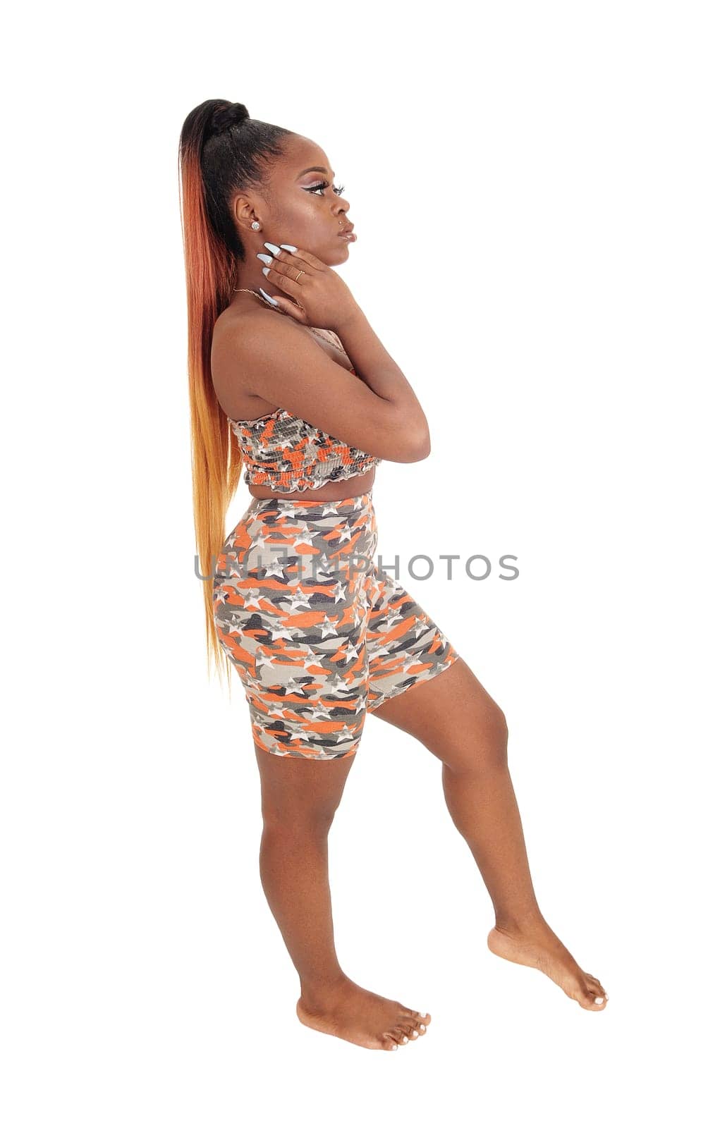 A lovely young African woman standing in a beach outfit in the studio.in profile, isolated for white background.