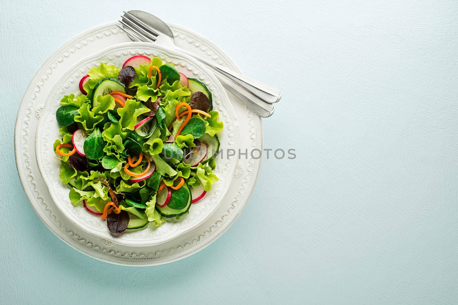 Healthy Green salad with fresh vegetables on blue table background