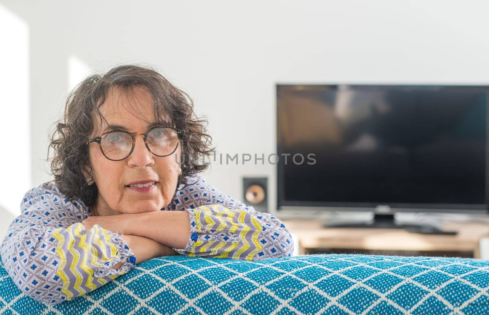 portrait of a beautiful brunette senior woman on the sofa
