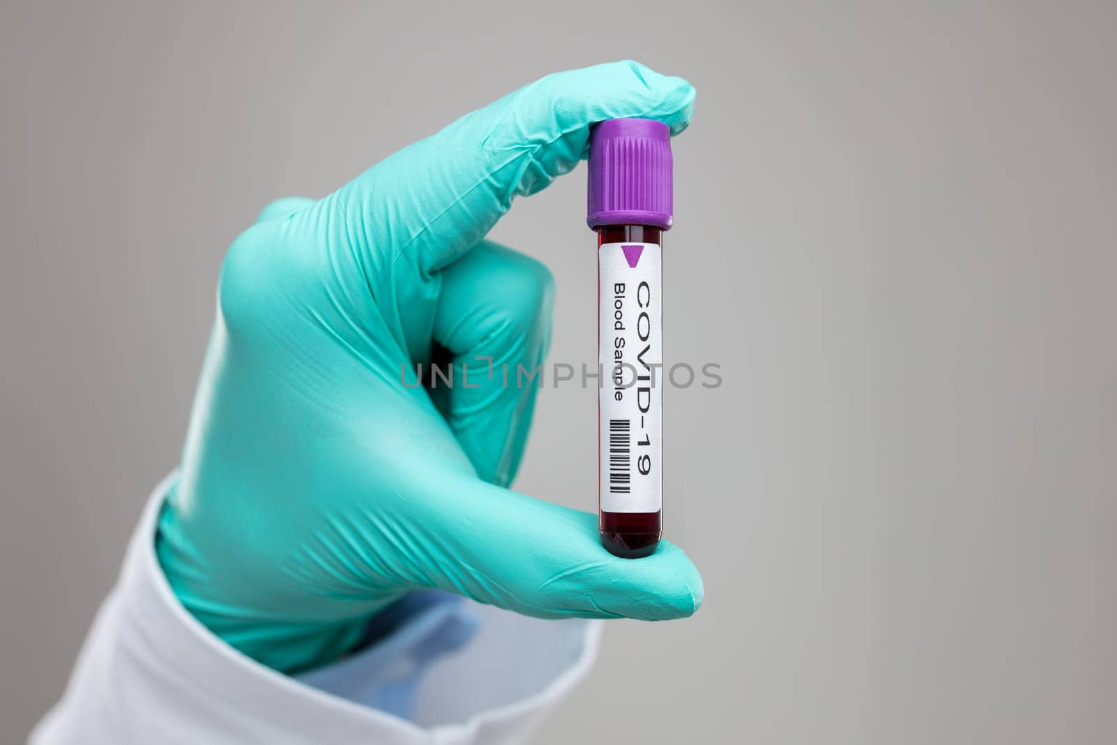 Doctor wearing respiratory mask and holding the Coronavirus Covid-19 blood sample