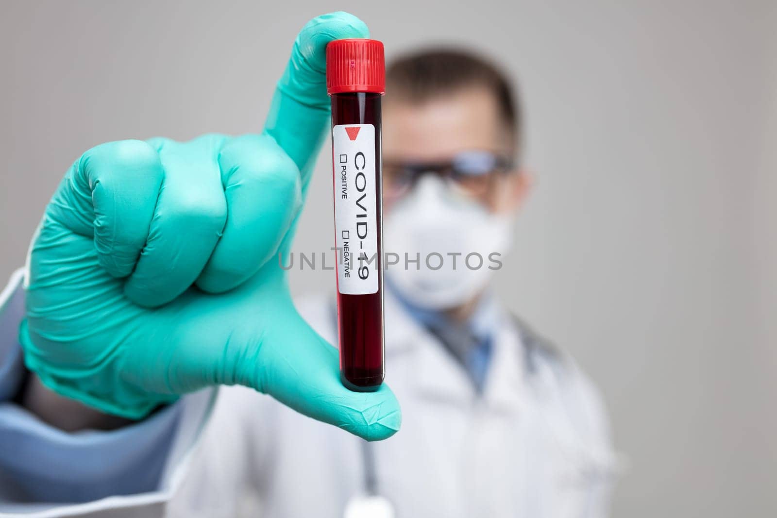Doctor wearing respiratory mask and holding the Coronavirus Covid-19 blood sample
