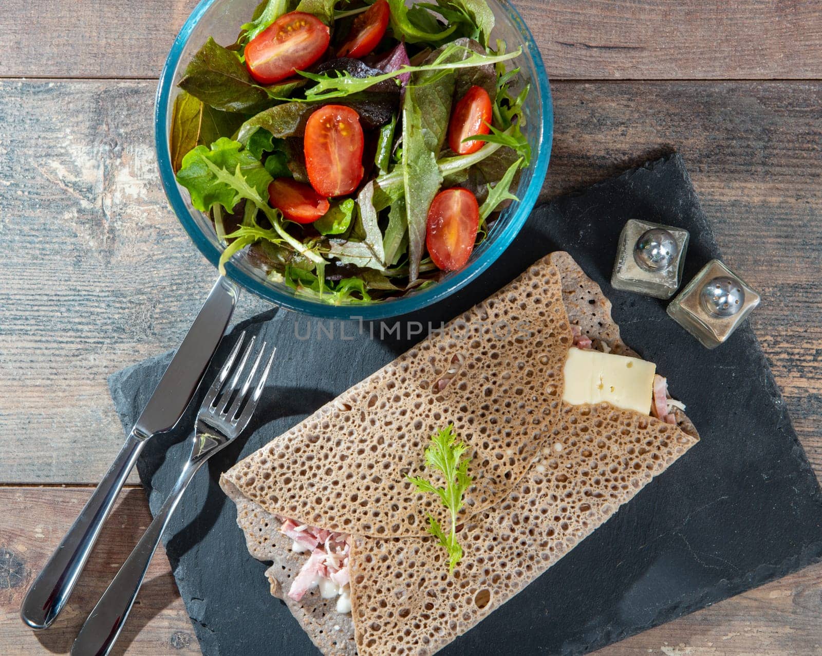Breton crepe with cheese and bacon on the wooden background