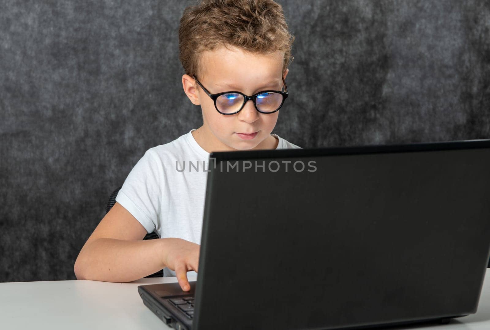 Happy boy sitting with a laptop computer