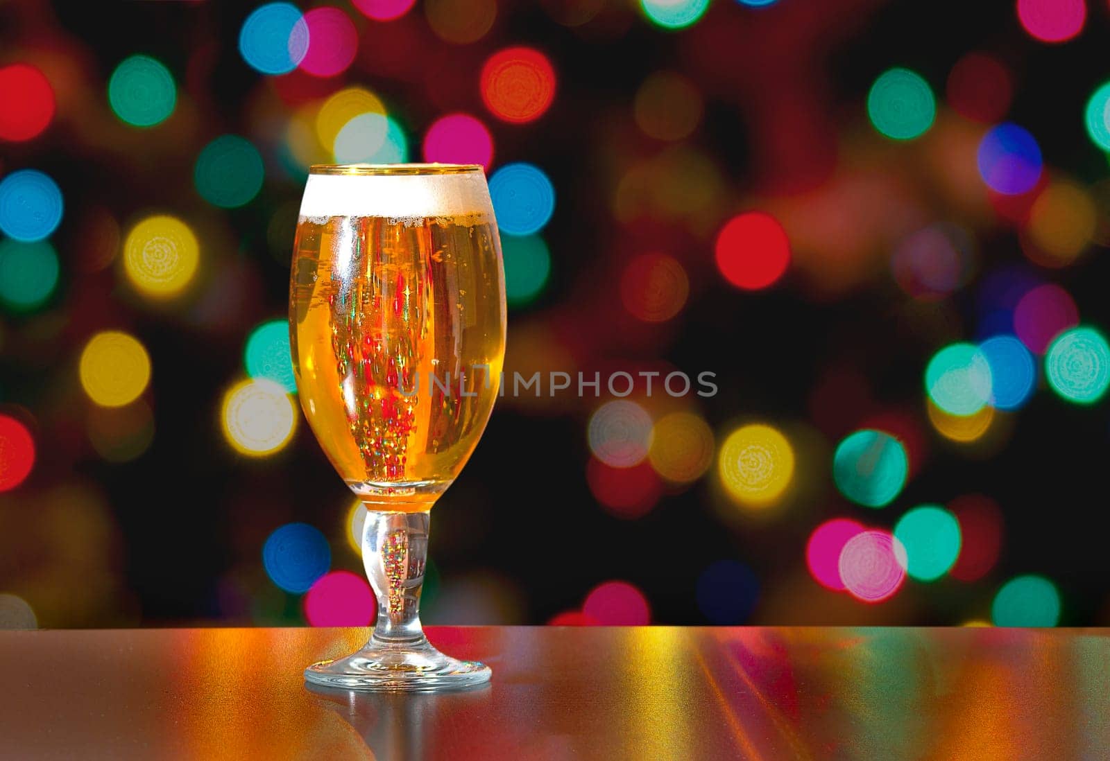 A Cup of Stella Artois full of beer with holiday colorful lights in background