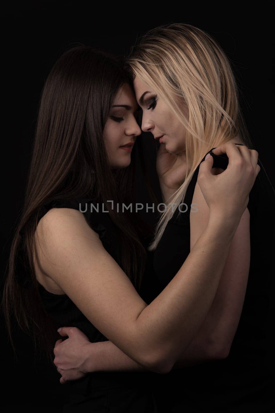 Portrait of two beautiful young women on black background.