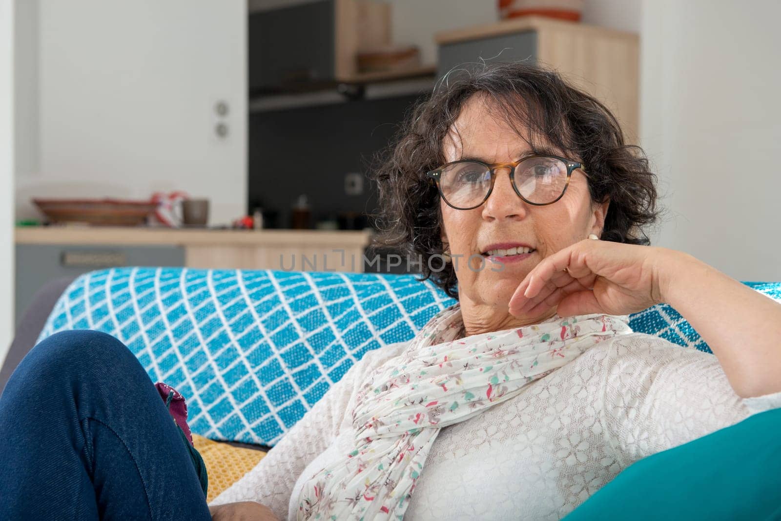 Pretty brunette senior woman relaxing on a couch