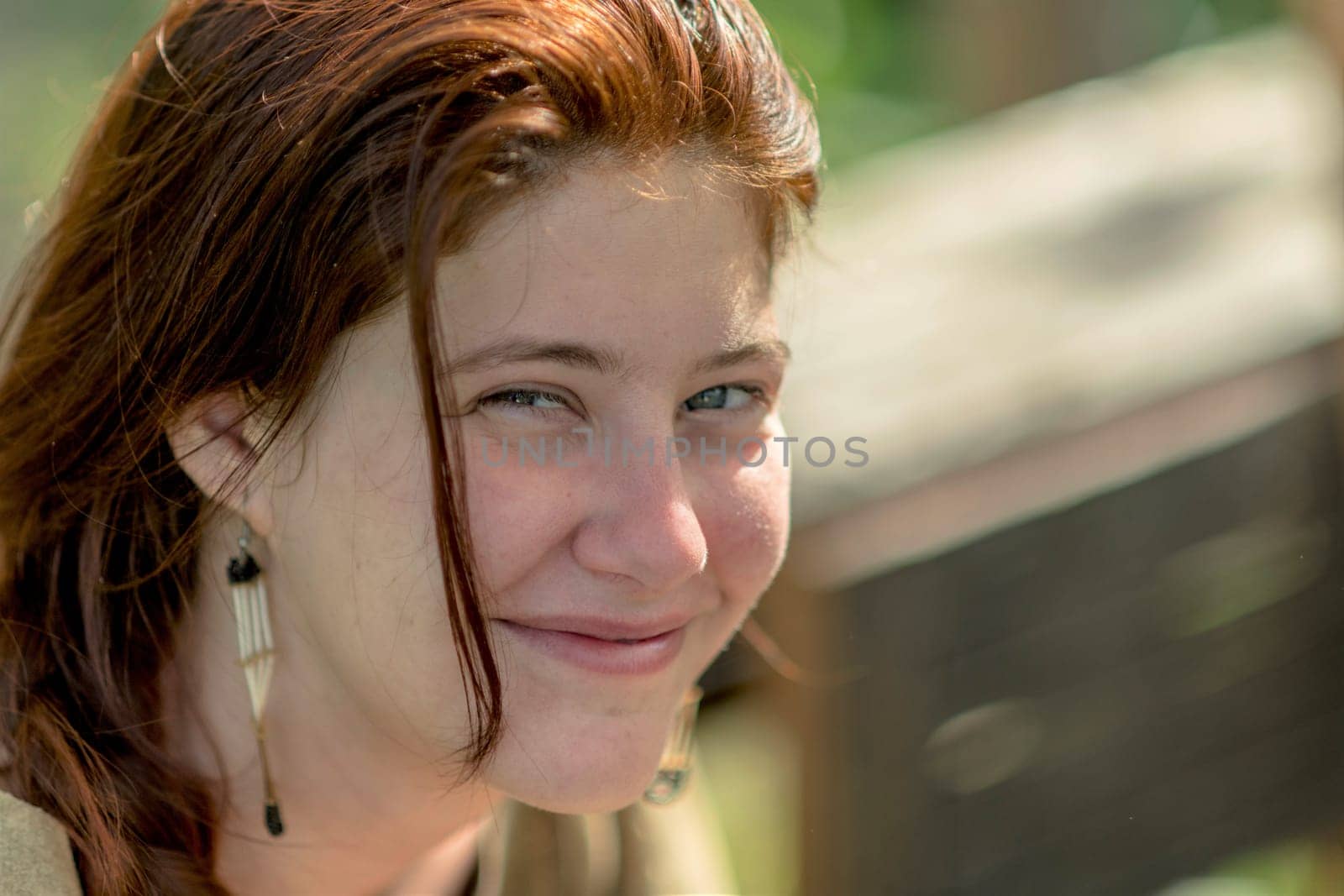 Portrait of a laughing young girl with dark hair against blurred background