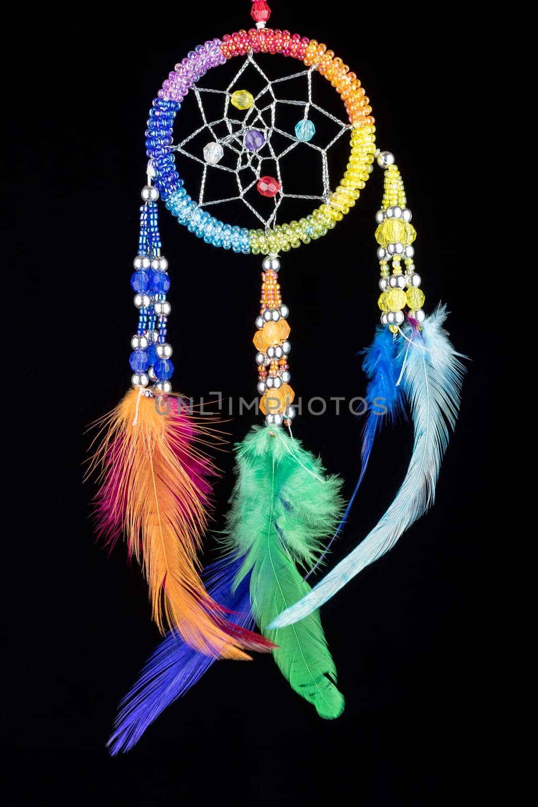 Pearl-embroidered dream catcher with colorful feathers and pearls against a black background