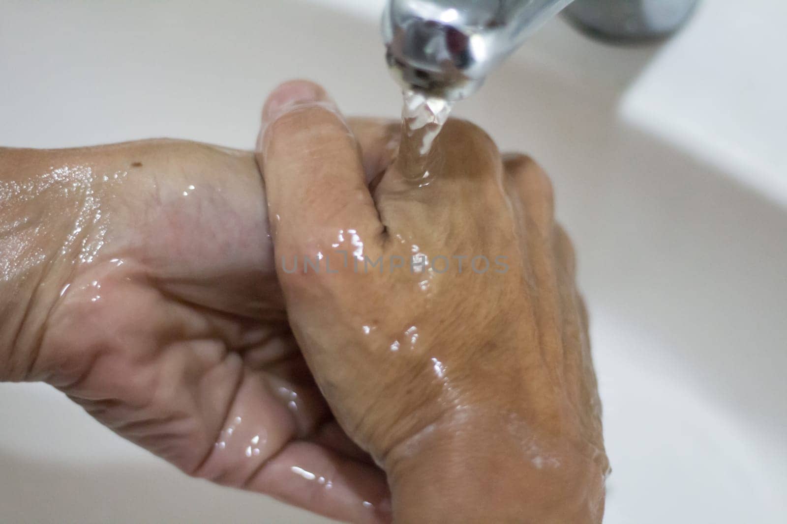 woman's hands washing with soap and water