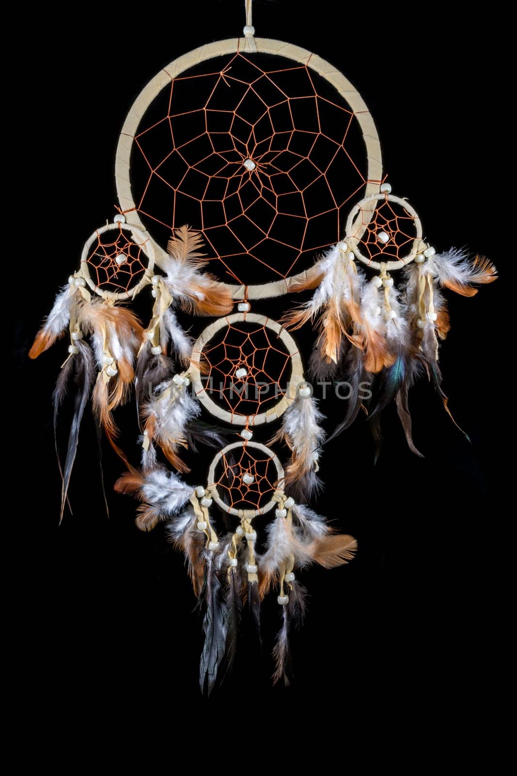Pearl-embroidered dream catcher with colorful feathers and pearls against a black background