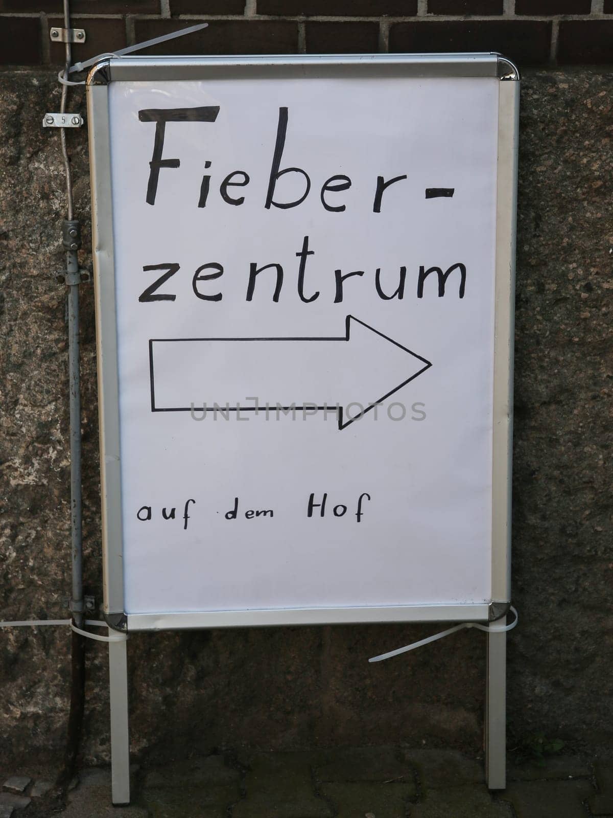 Signpost to the fever center in the courtyard during the corona virus pandemic