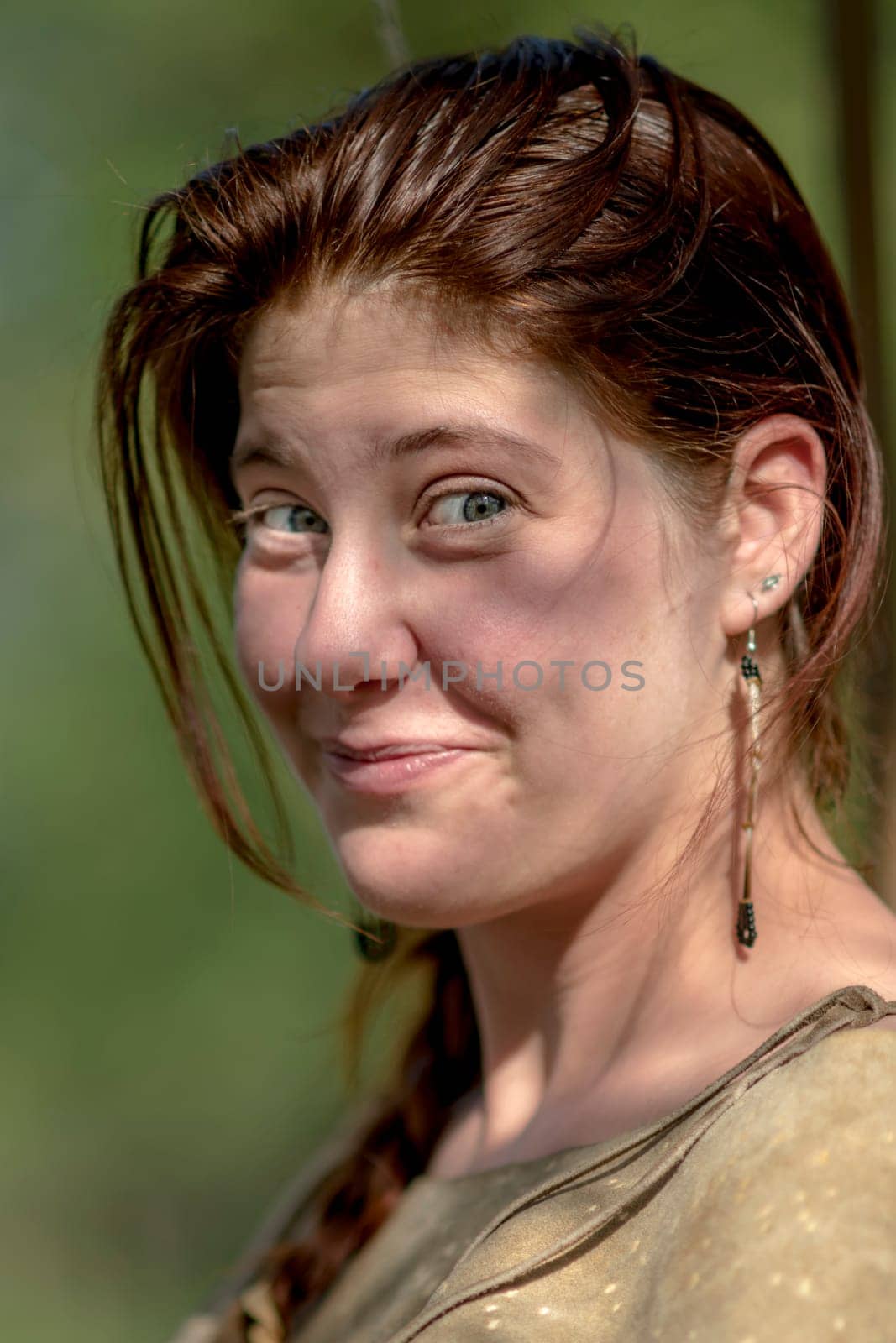 Portrait of a laughing young girl with dark hair against blurred background