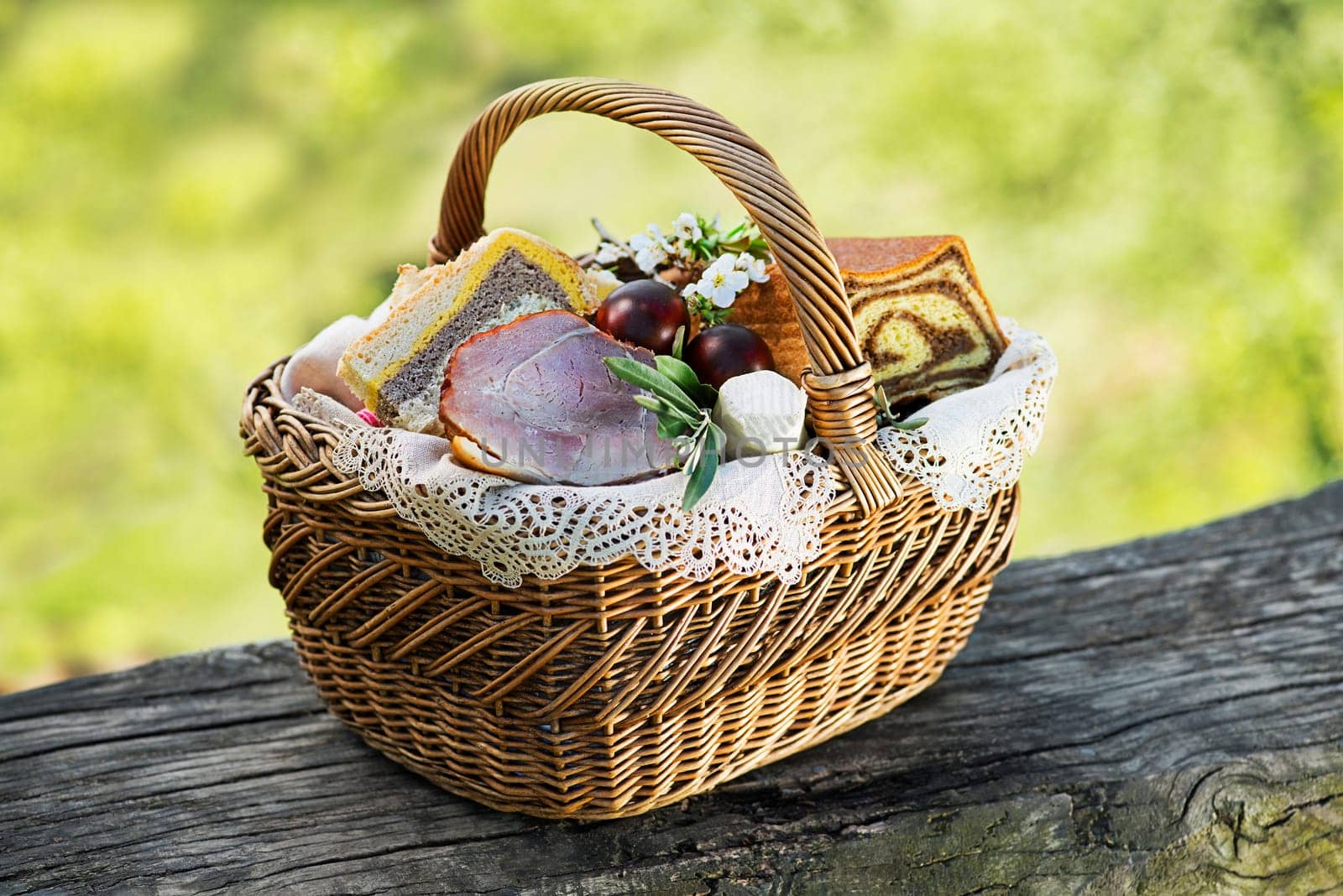 Easter traditional food with ham, eggs and bread in basket. Holidays background outdoor