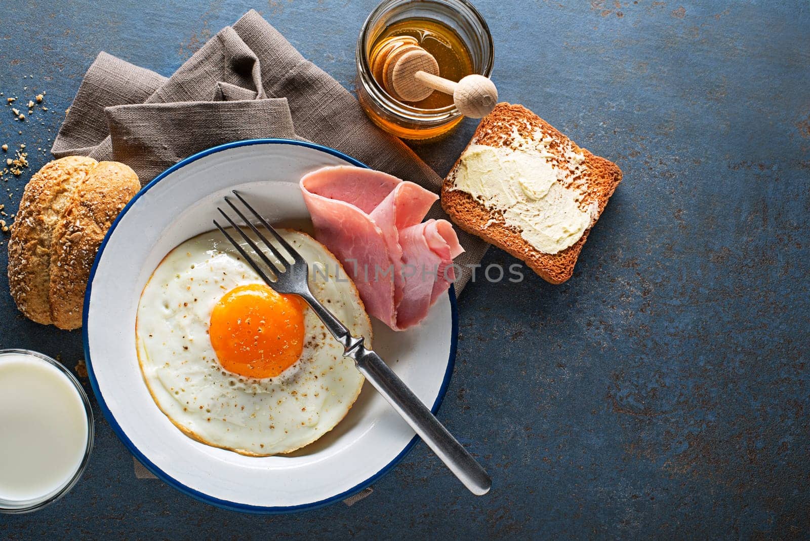 Breakfast meal of fried egg with ham on table top view. Healthy breakfast food.