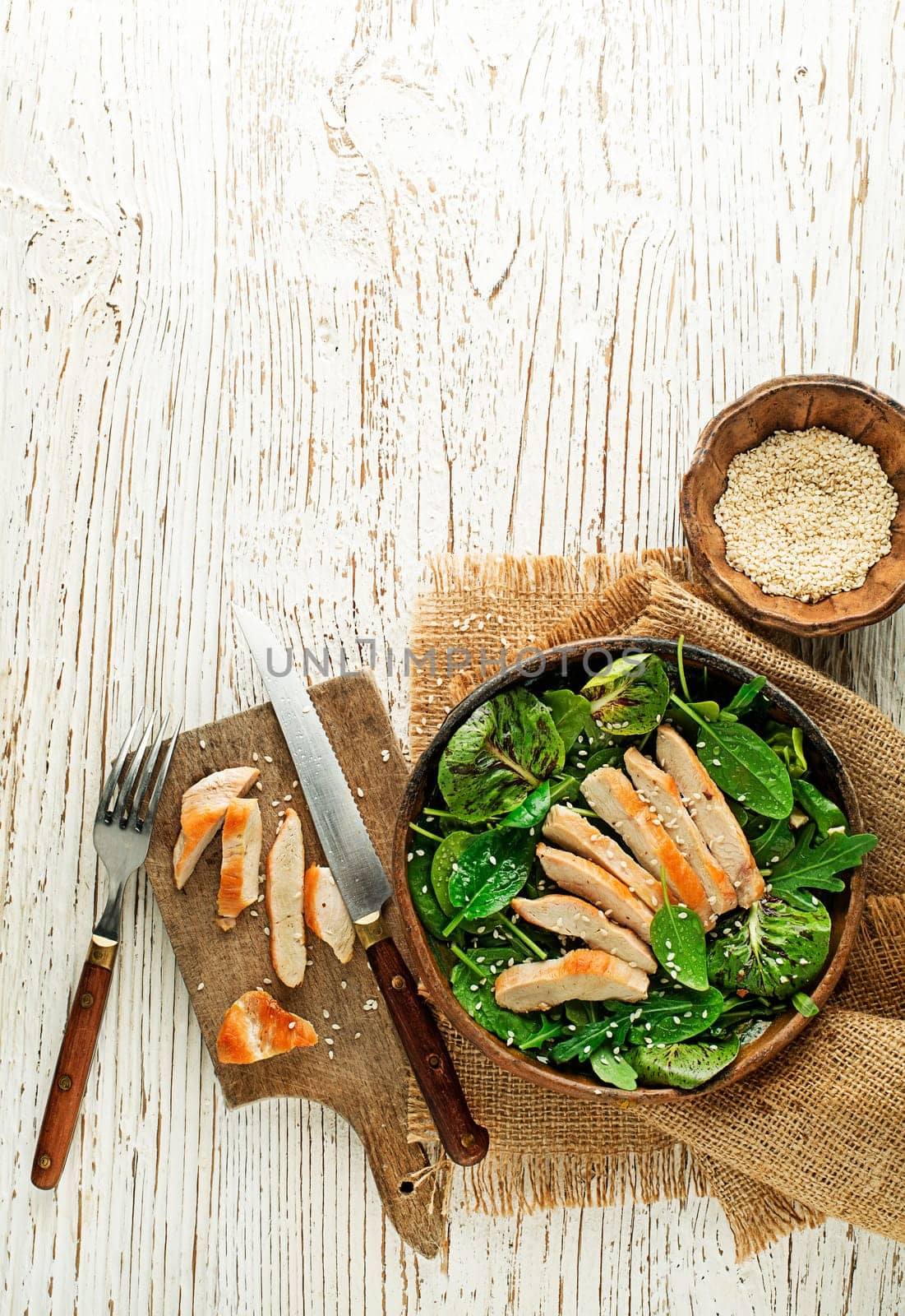 Healthy green salad with chicken breast on wooden table