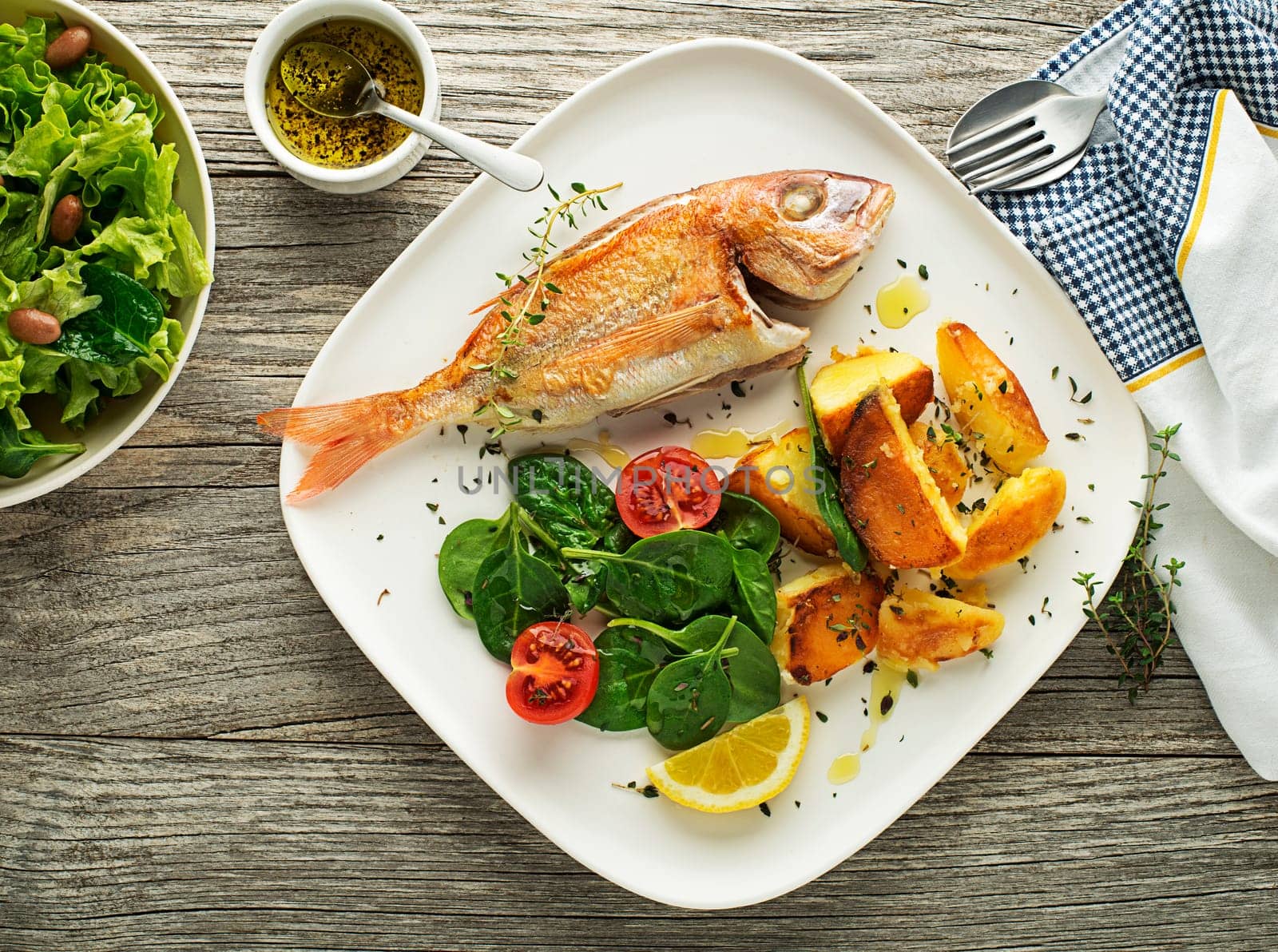 Delicious grilled fish meat with spinach and potatoes on vintage background. Healthy diet meal