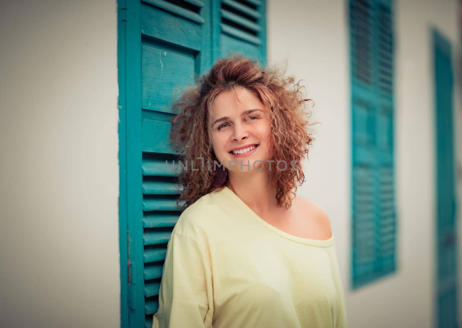 Outdoor portrait of a beautiful woman next to shutter window