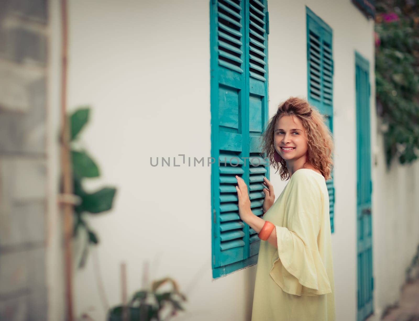 Outdoor portrait of a beautiful woman next to shutter window