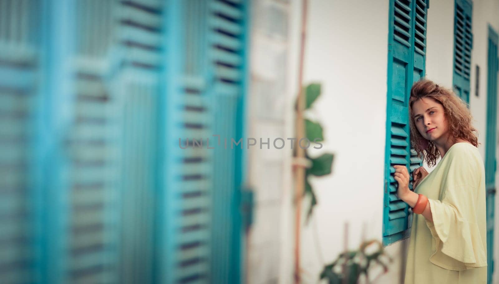 Outdoor portrait of a beautiful woman next to shutter window