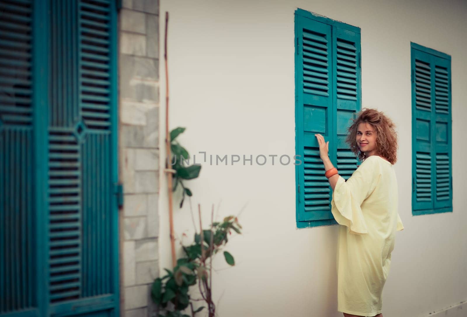 Outdoor portrait of a beautiful woman next to shutter window
