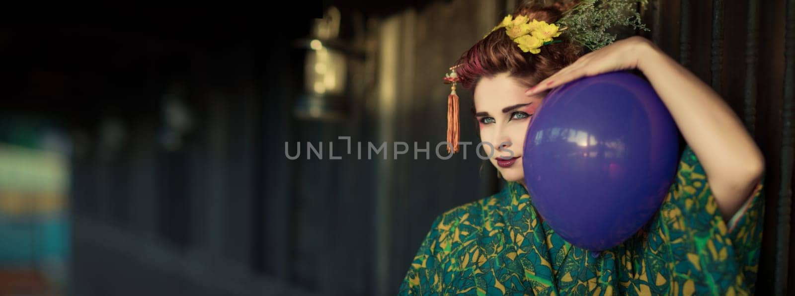 Fine art portrait of european woman in Japanese Geisha style wearing kimono with balloon