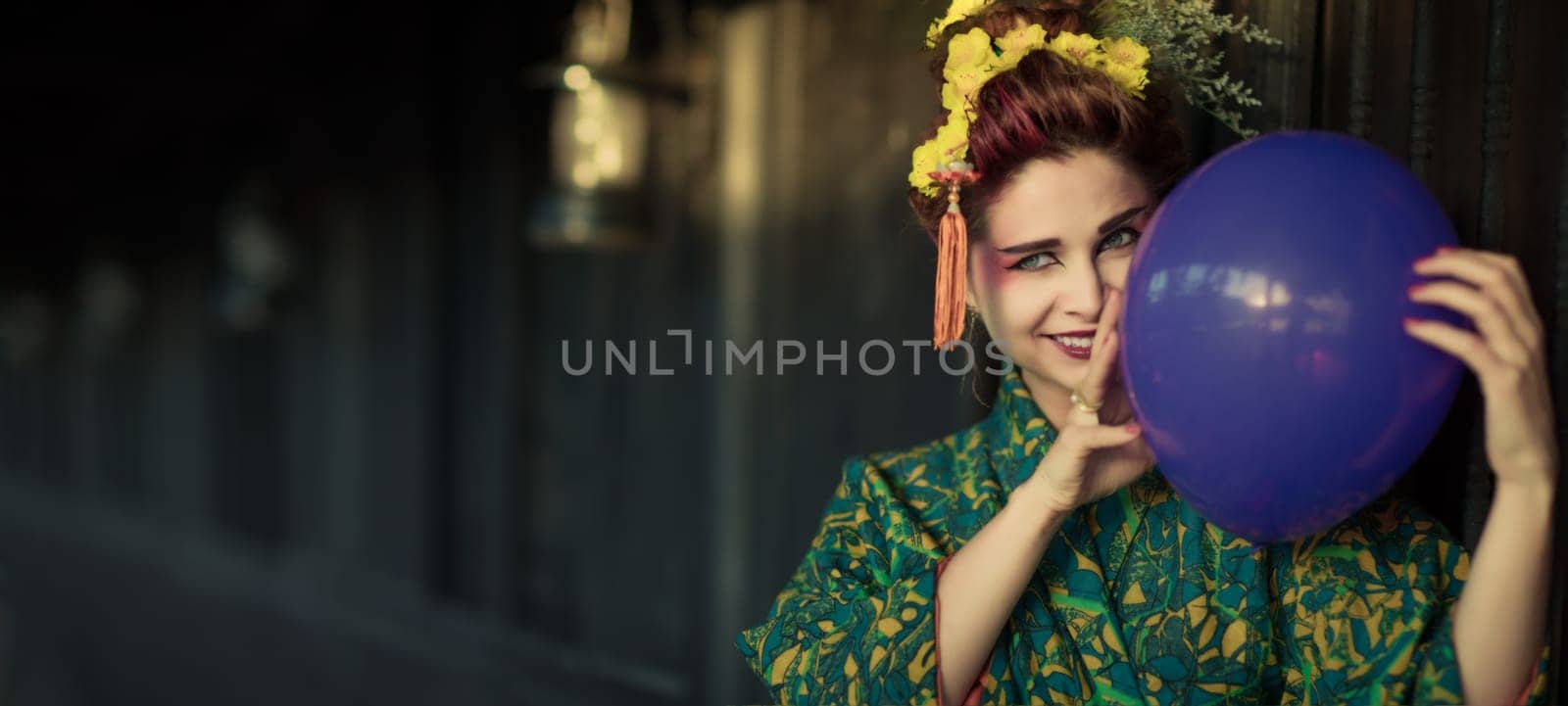 Fine art portrait of european woman in Japanese Geisha style wearing kimono with balloon