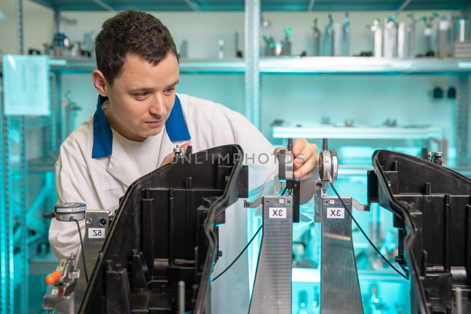 engineer measures plastic components for the production of lights for the automotive industry in a factory on a digital 3D machine.