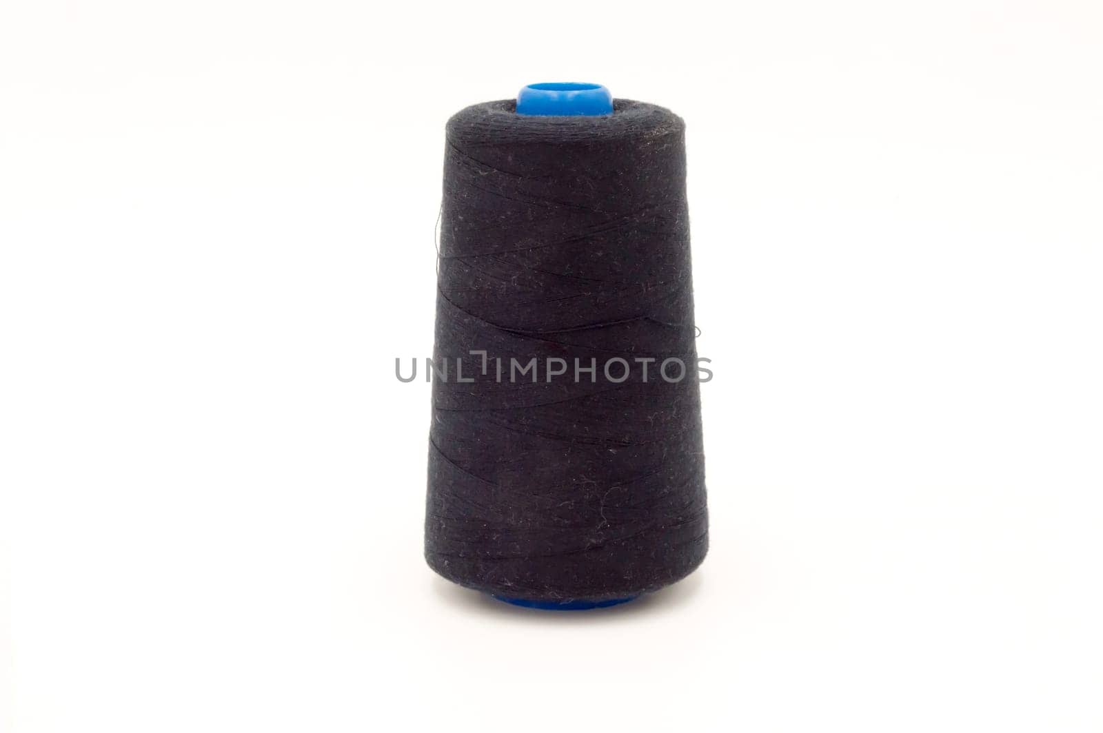 Close up of spool of colored thread on white background