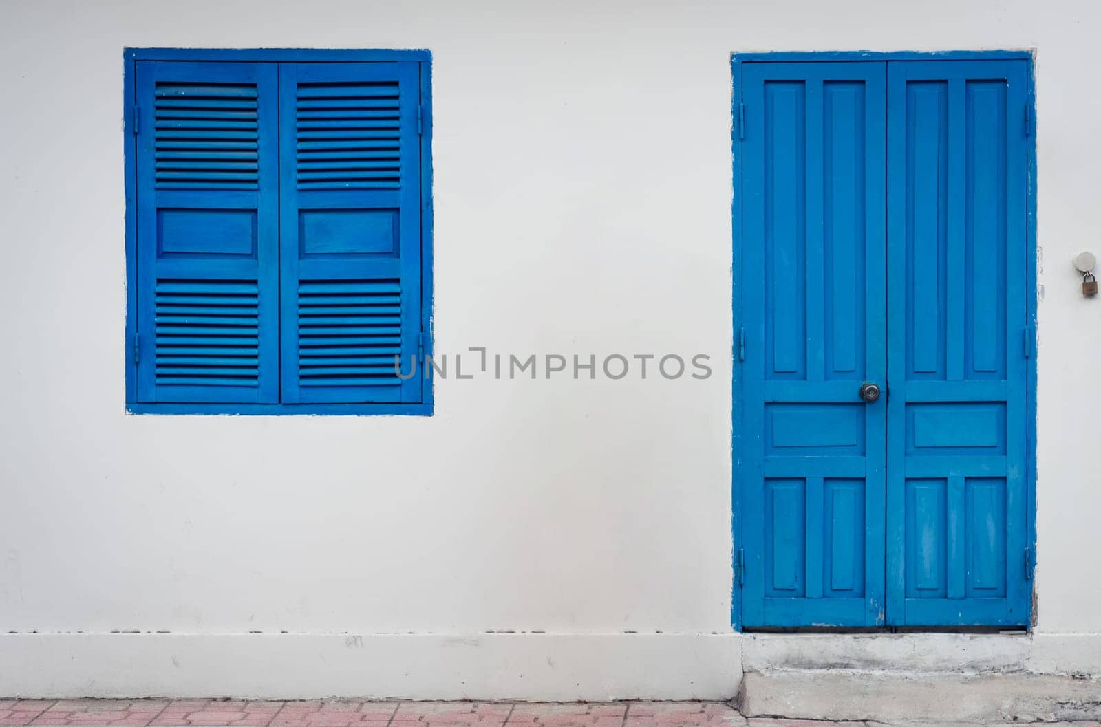 White wall with closed shatter window and door