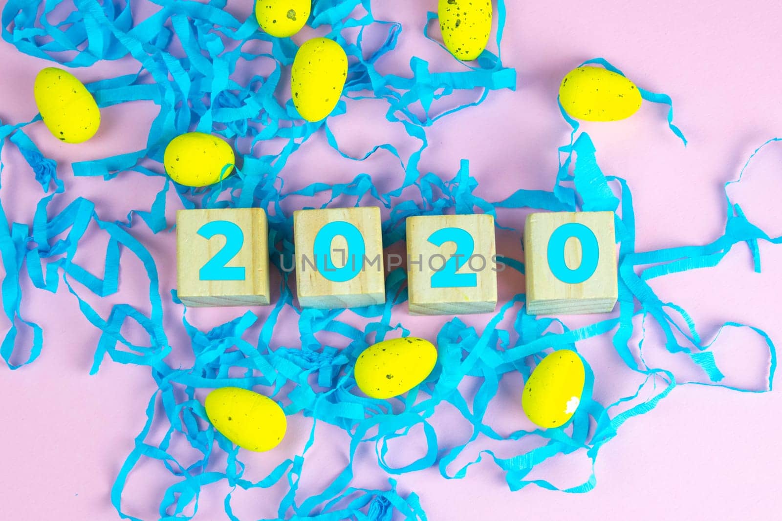 Word Easter on wooden cubes and surrounded with multiple egg decorations as a festive Easter background composition.