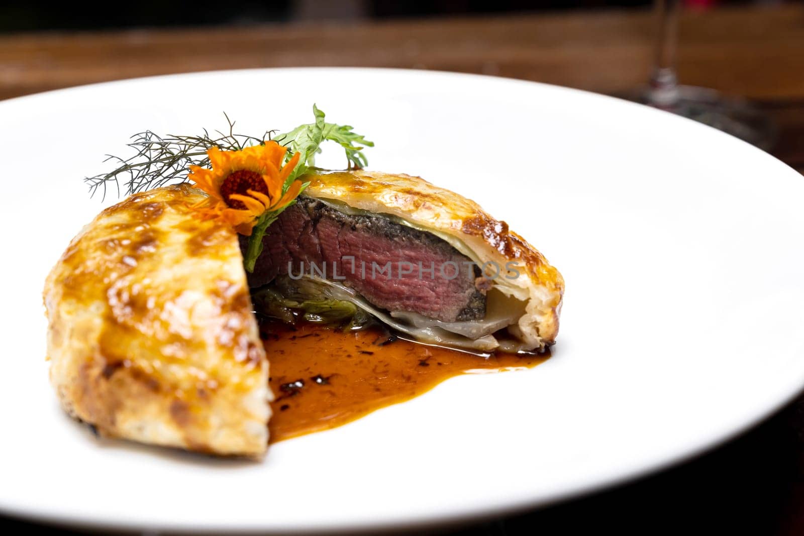 Roasted Beef Wellington with gravy brown savory sauce, international gourmet cuisine of stuff beef meat in baked bread puff. Unising for recipe menu pf food and drink industry.