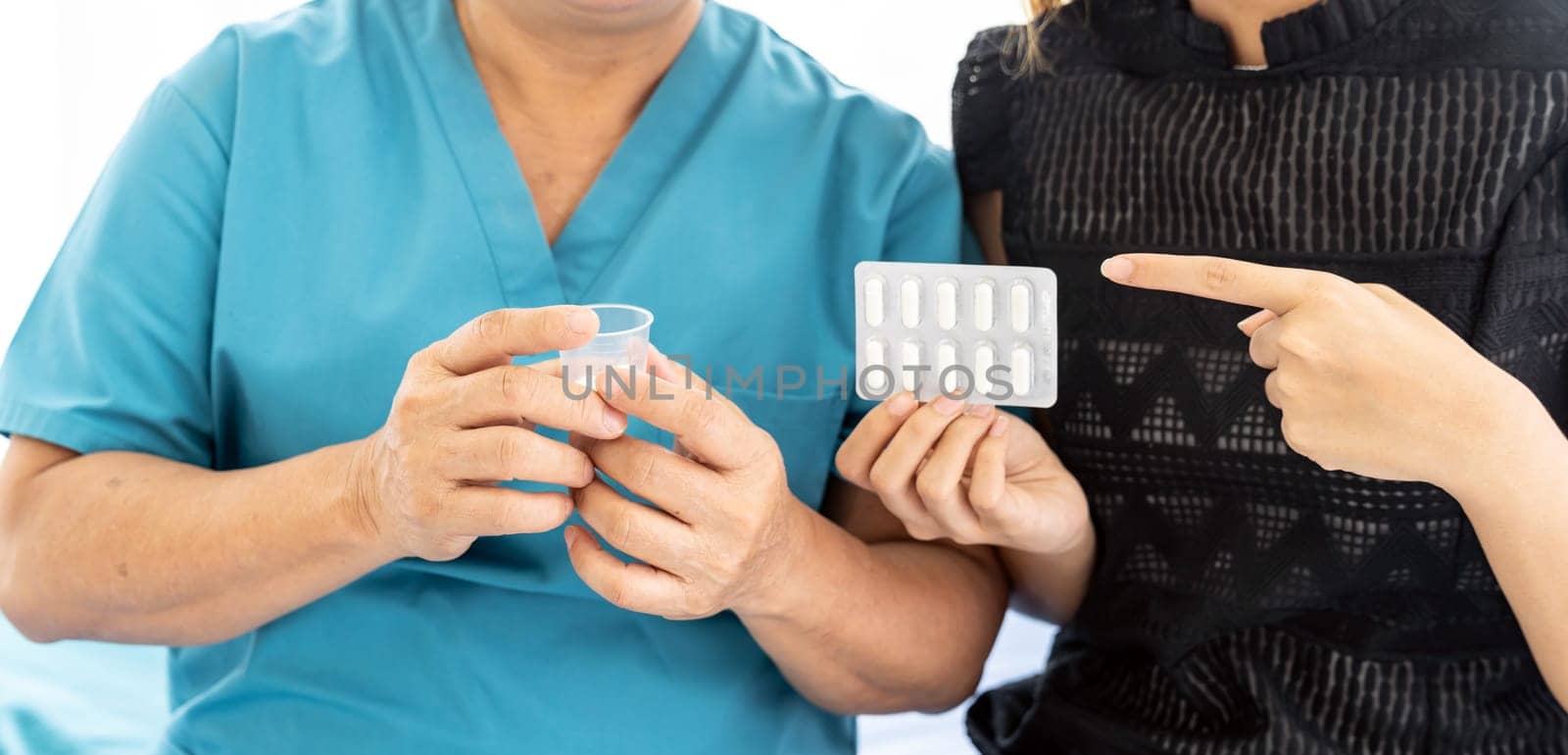 Close up of Caregiver woman helping old elderly woman taking medicine pill on the bed and check up her at home.