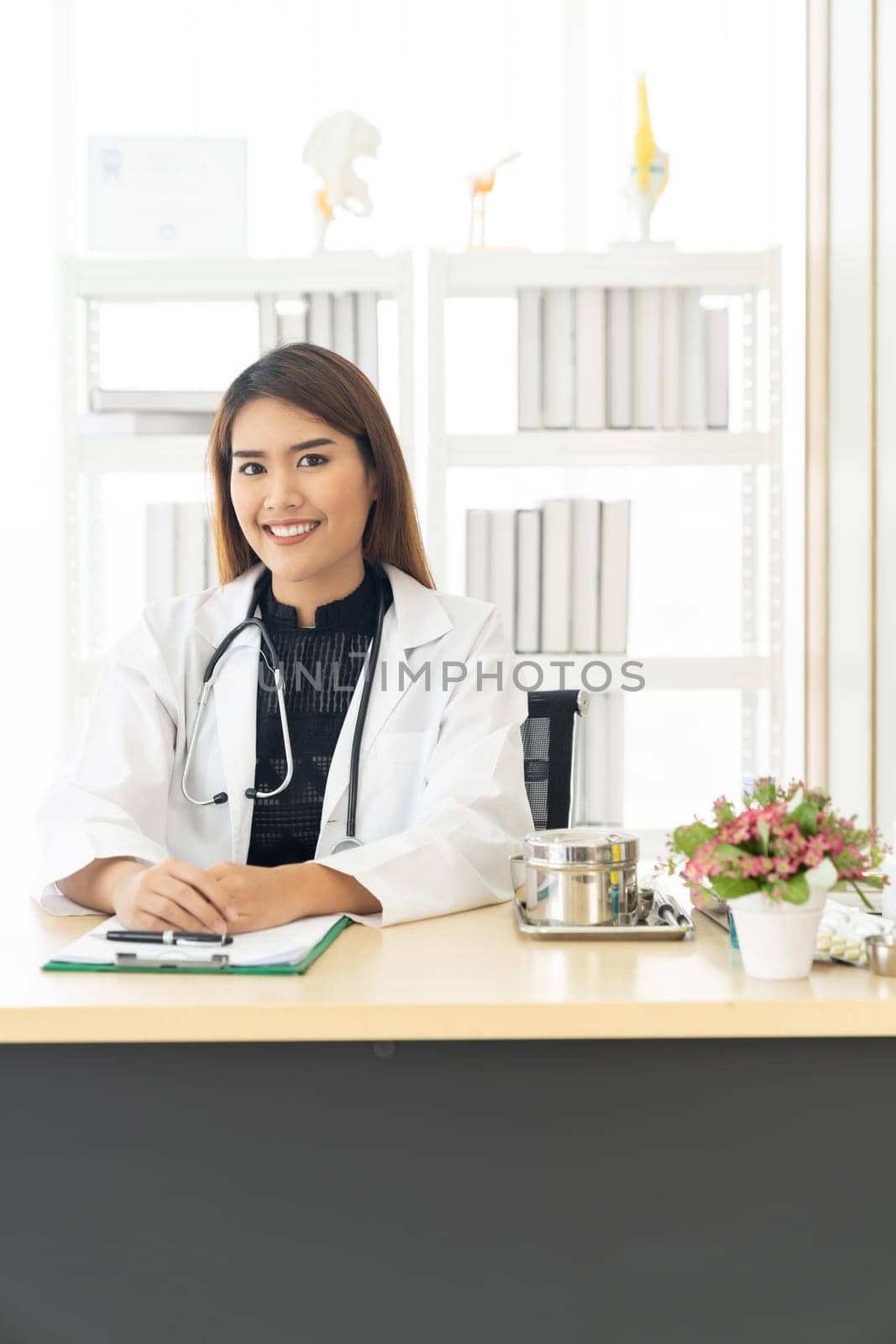 Portrait confident female doctor medical professional sitting in examination room in hospital clinic. Positive face expression