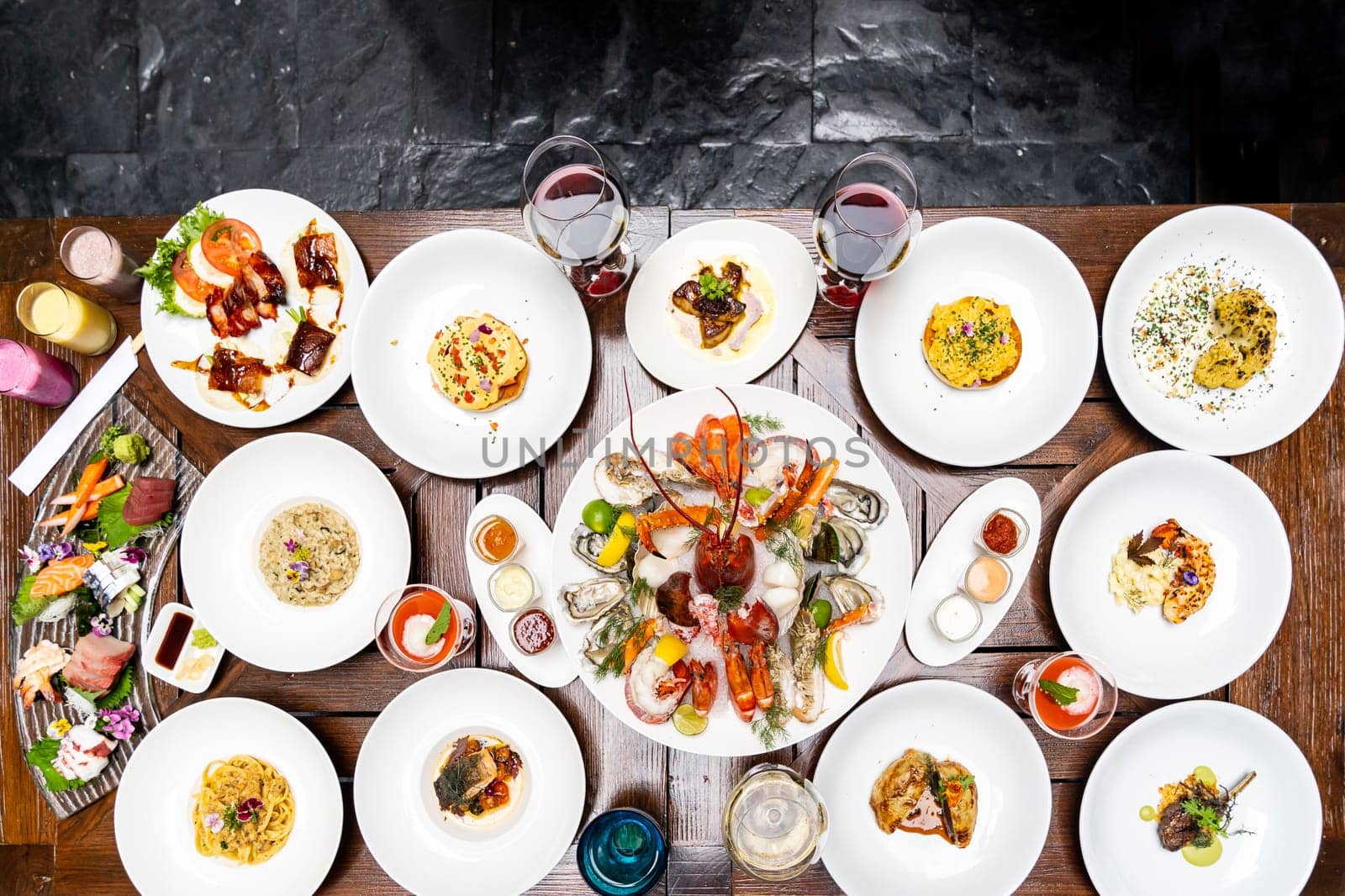 Table top view premium variety of international food in restaurant of lobster shrimp steak beef lamb pasta spaghetti risotto rice sushi sashimi and wine using for buffet food drink background.