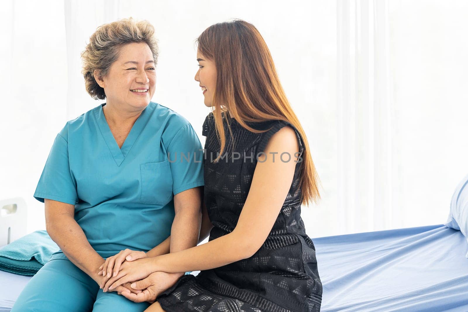 Cute young daughter embracing hug her happy old elderly mother with love at home