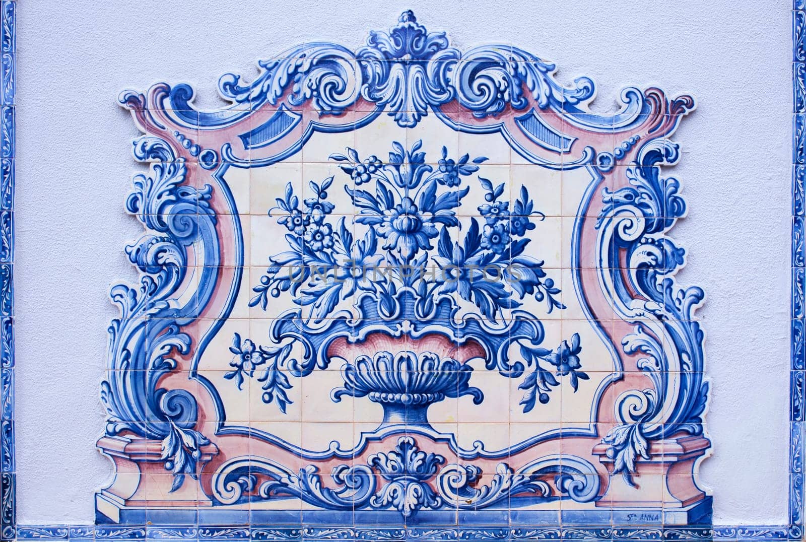 Lisbon, Portugal - March the 1st, 2020: Portuguese tin-glazed ceramic tilework decorates Lisbon walls. Vase made by Sant’Anna Factory