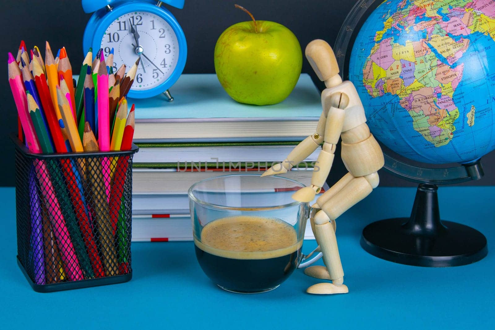 A stack of books with a globe, a glass of pencils, a clock apples and coffee.