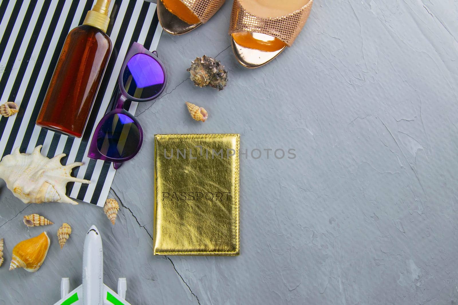 Travel concept. Preparation for the tour: passport, women's shoes, plane, glasses, tanning oil and seashells.