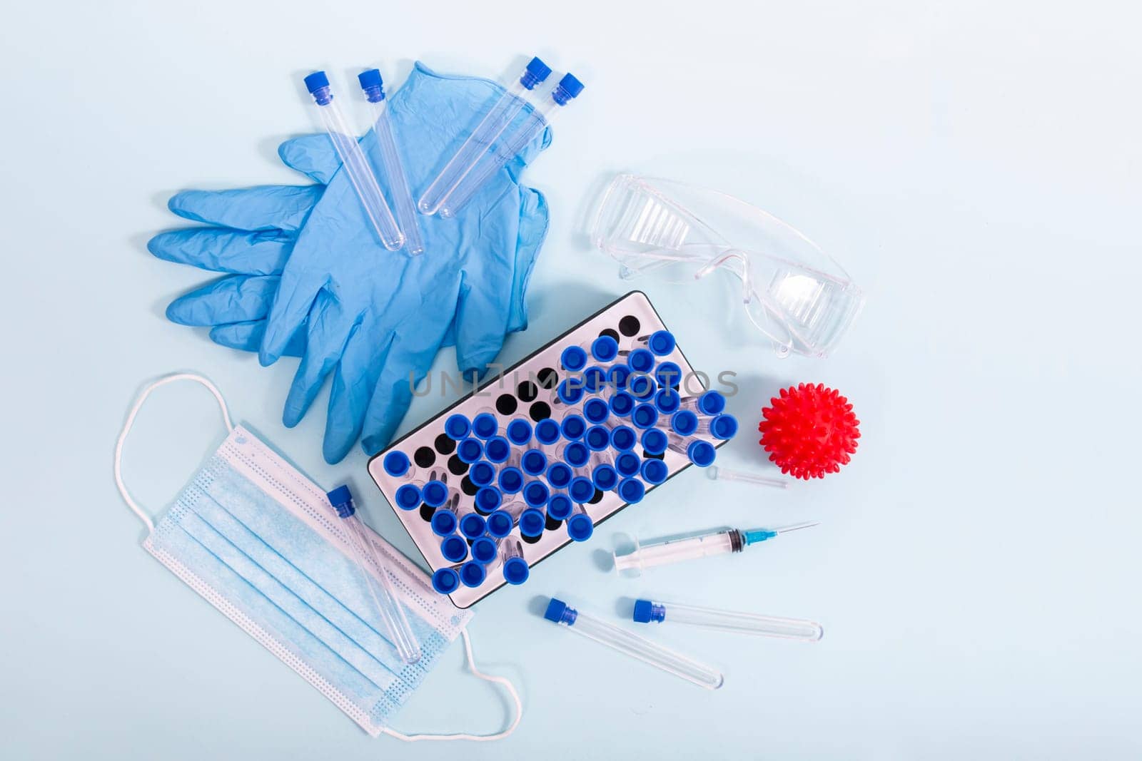 Several laboratory objects including protective mask, vial rack, testing tubes and other stuff.