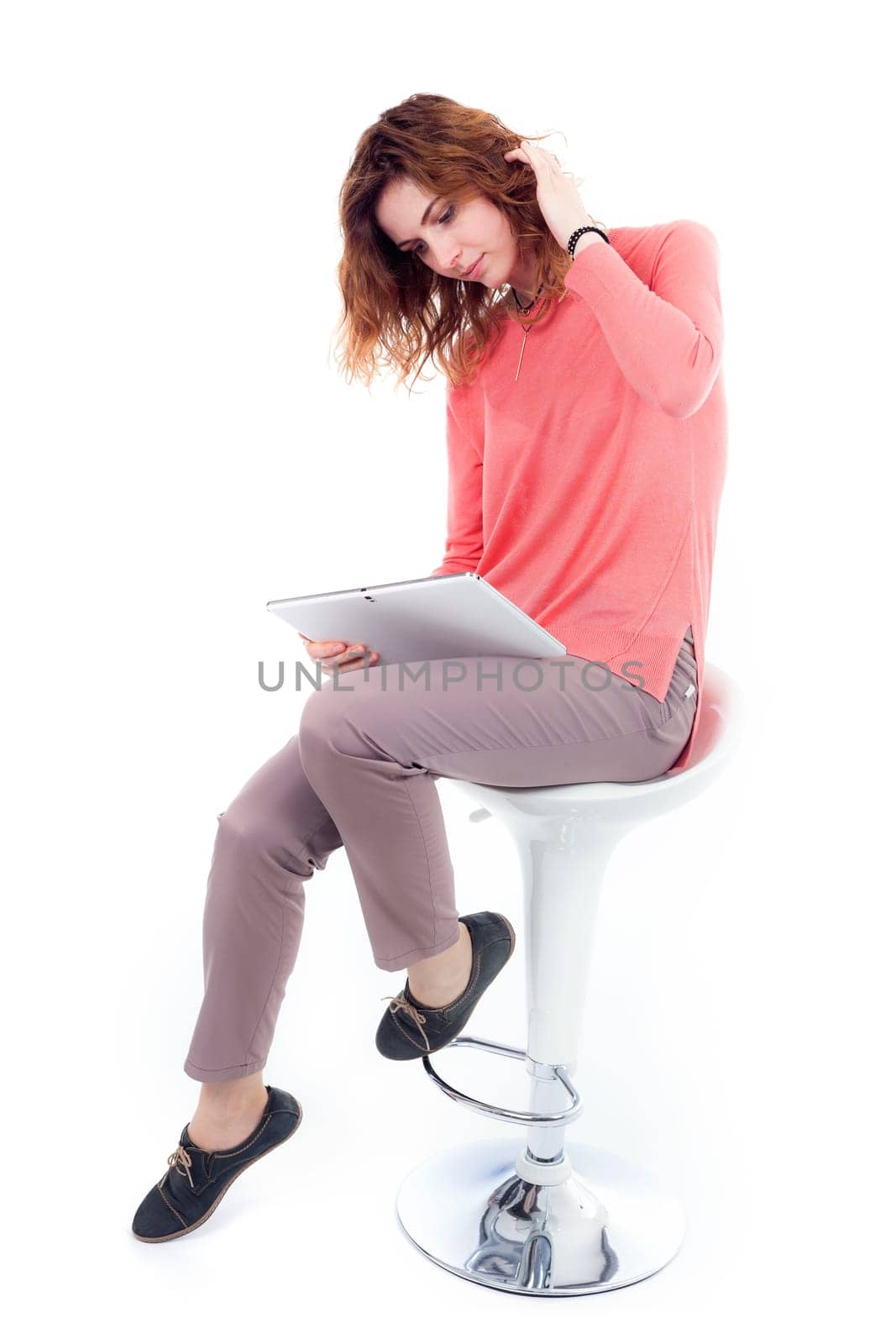 Portrait of cute joyful woman with trendy hairstyle wearing basic t-shirt talking on mobile phone isolated over white background.