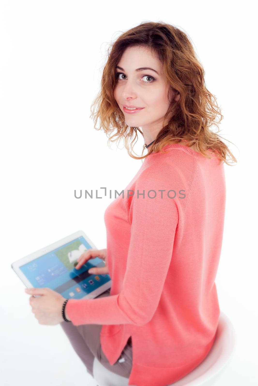 Portrait of cute joyful woman with trendy hairstyle wearing basic t-shirt talking on mobile phone isolated over white background.