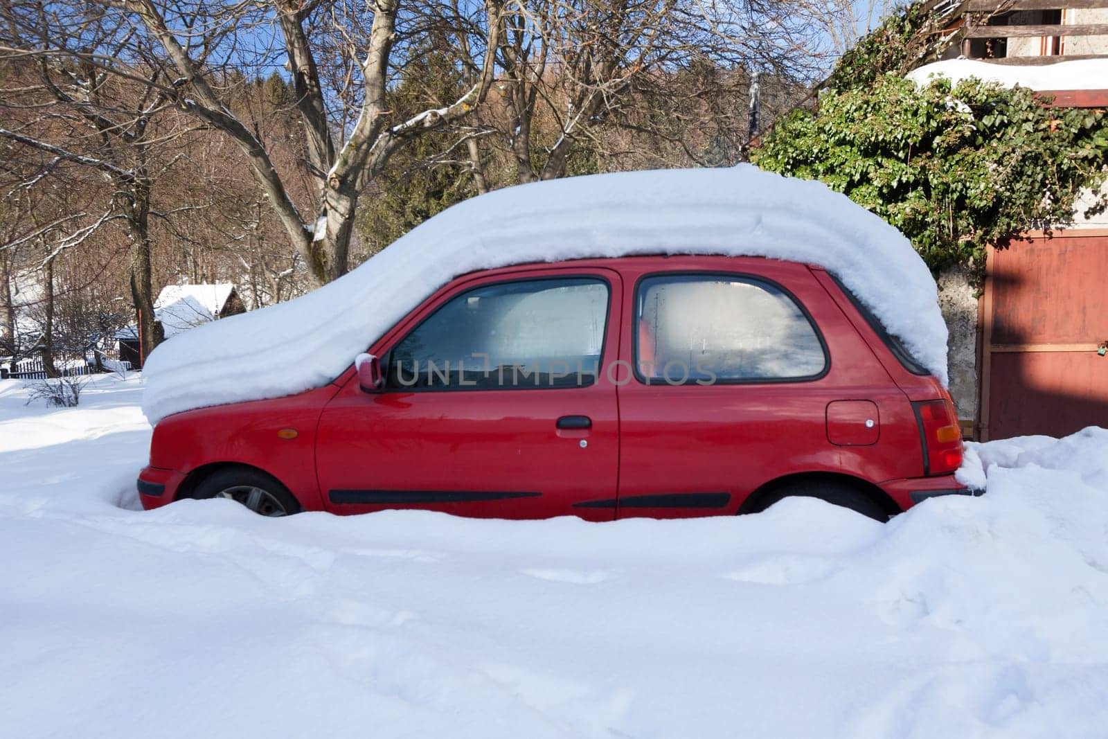 Red car sunken in snow, Czech Republic